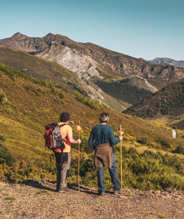 dos hombres despaldas observando la montana tras hacer una ruta de senderismo